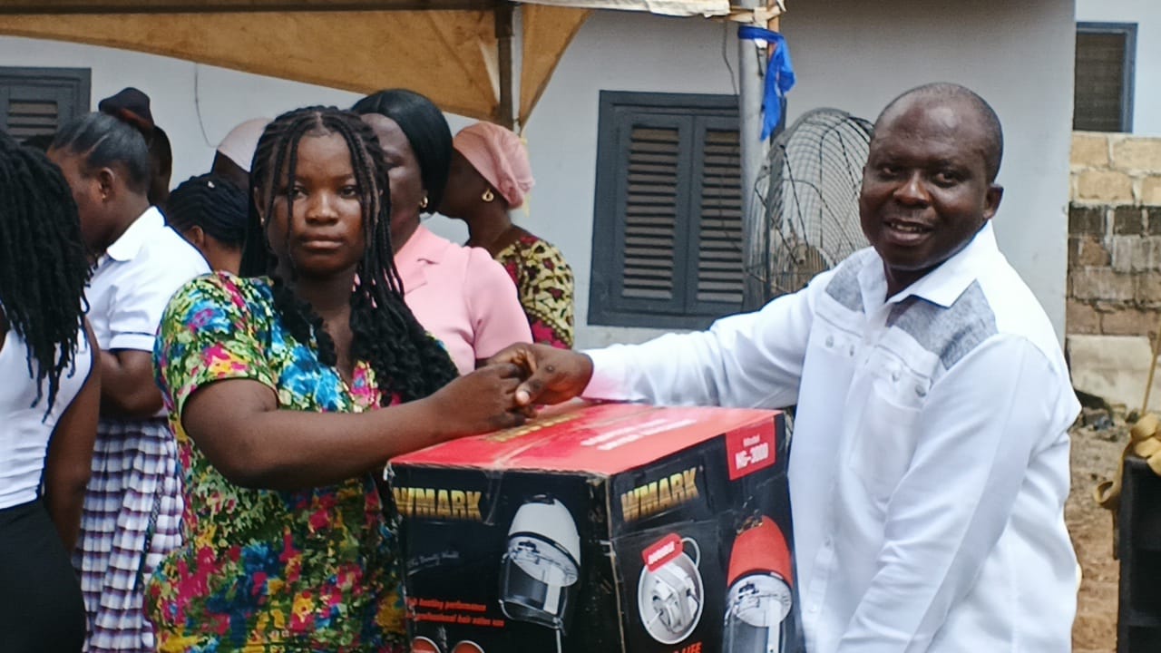 Mr Amponsah the Constituency Chairman right presenting item to beneficiary