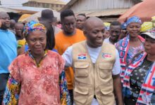 Chairman Odeneho Kwaku Appiah flanked by two traders at the Kumasi Race Course.